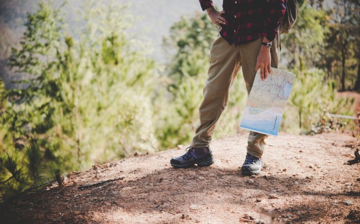 Persona con mappa mentre visita un percorso naturalistico