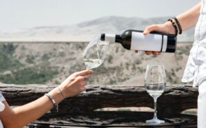 Uomo che versa il vino nel calice ad una donna durante una degustazione